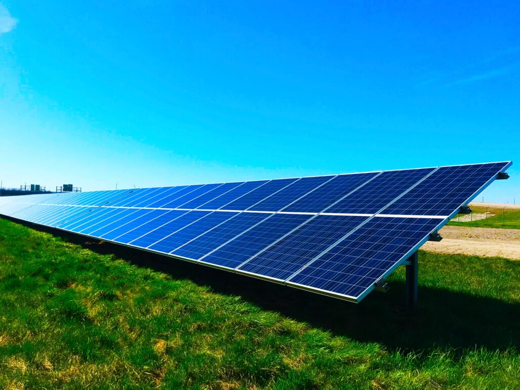 solar panels in open space, blue sky and green grass