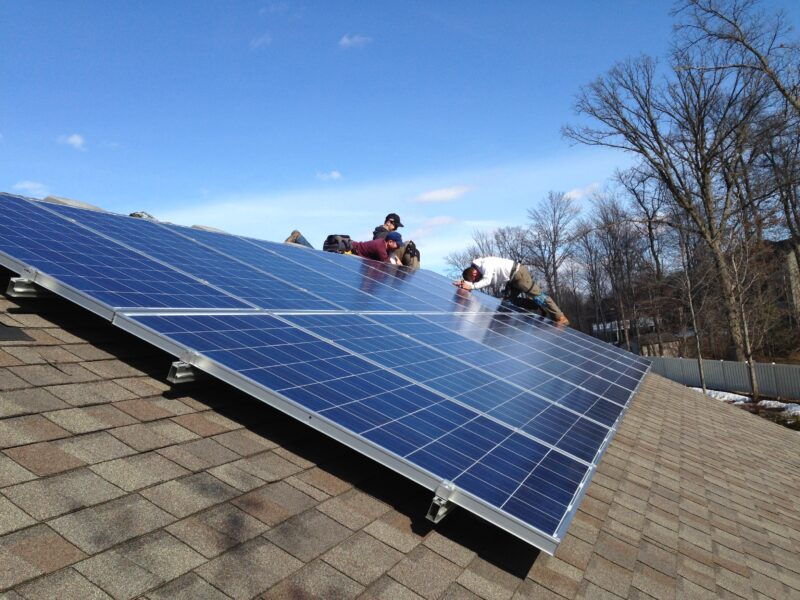 solar panel installers on a roof