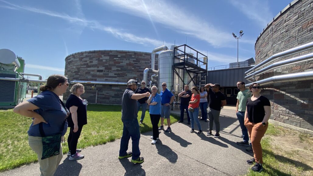 educators between two large brick tanks that are part of an anerobic digestor